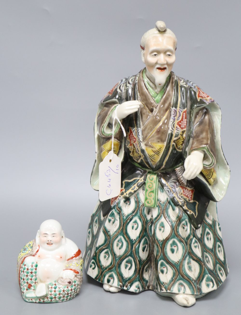 A Japanese ceramic model of a Samurai and a Chinese enamelled ceramic figure of a Buddha, tallest 31.5cm